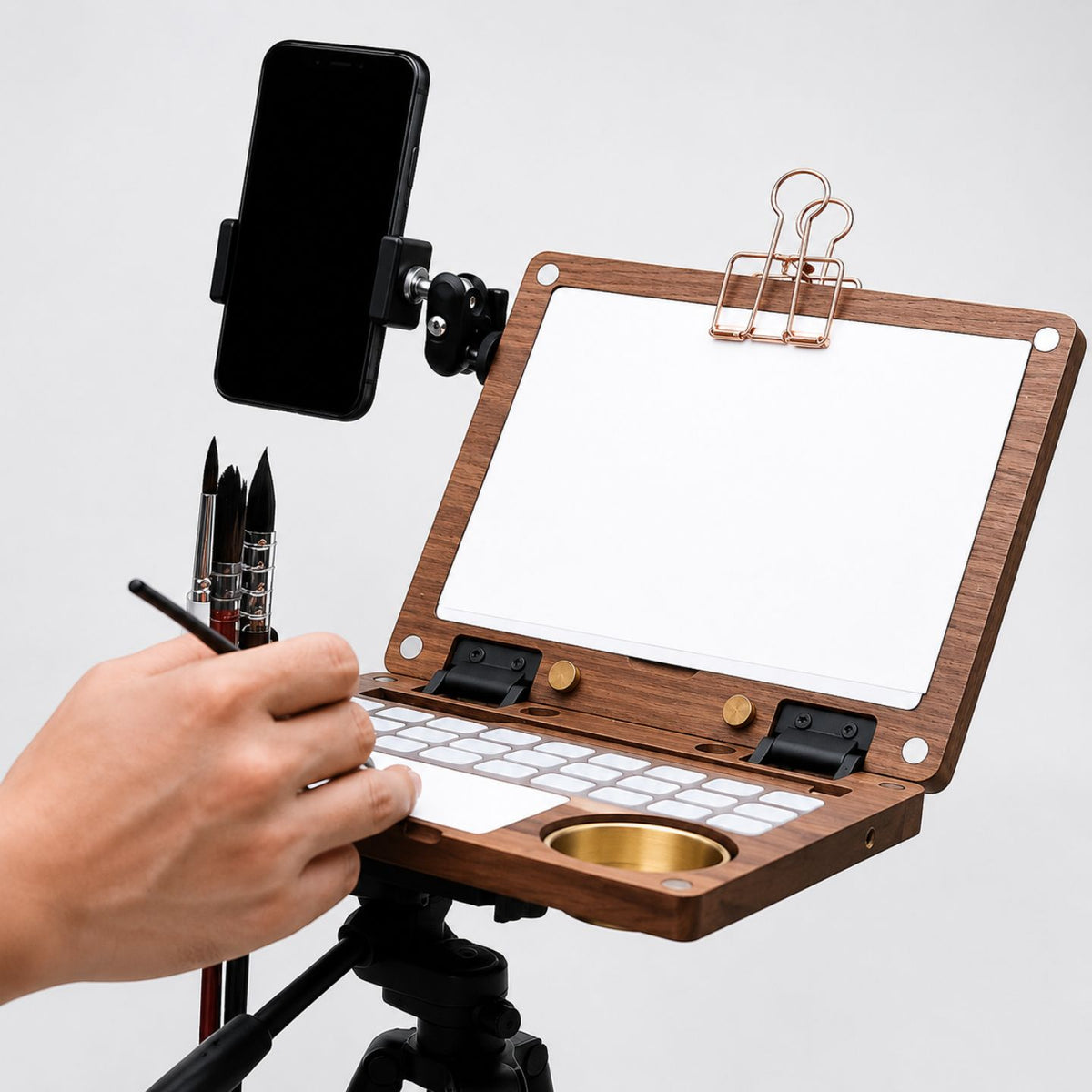 Walnut painting kit on a tripod with a phone holder and brushes during plein-air painting