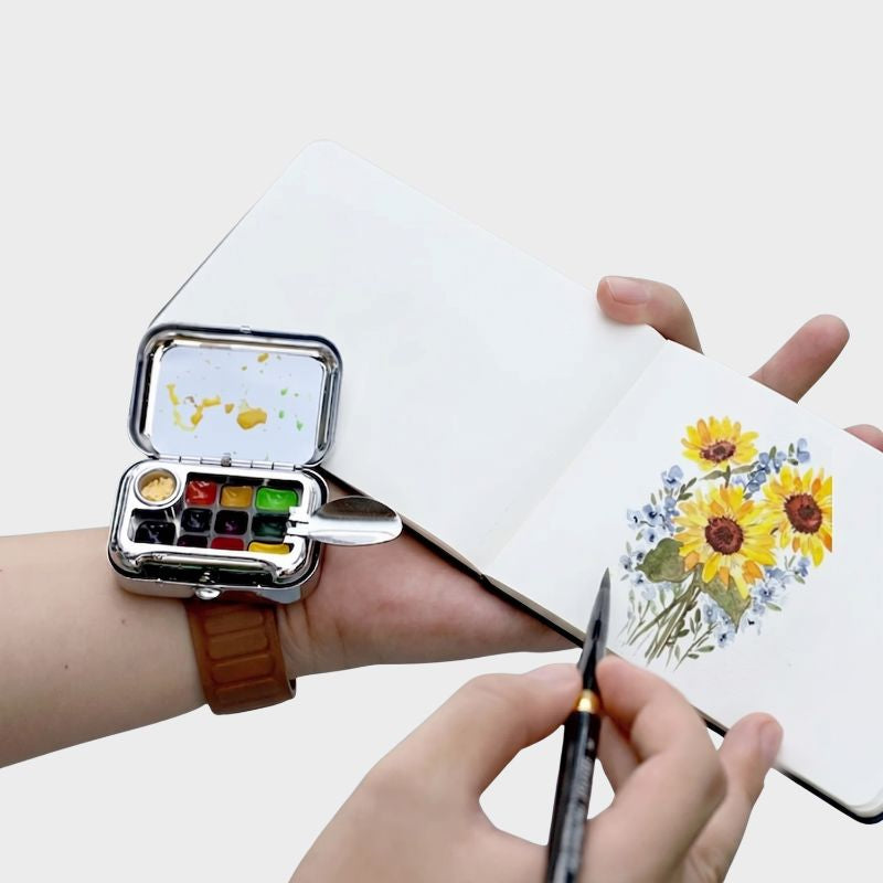 Artist painting sunflowers in sketchbook with Wrist Palette Kit — wearable watercolor for plein air