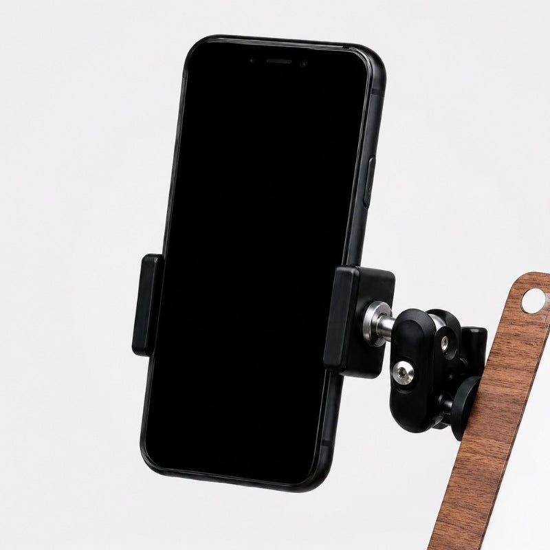 Adjustable ArtMate phone holder clamped to the walnut Master Edition kit panel, gripping a black smartphone on a multi-axis ball joint