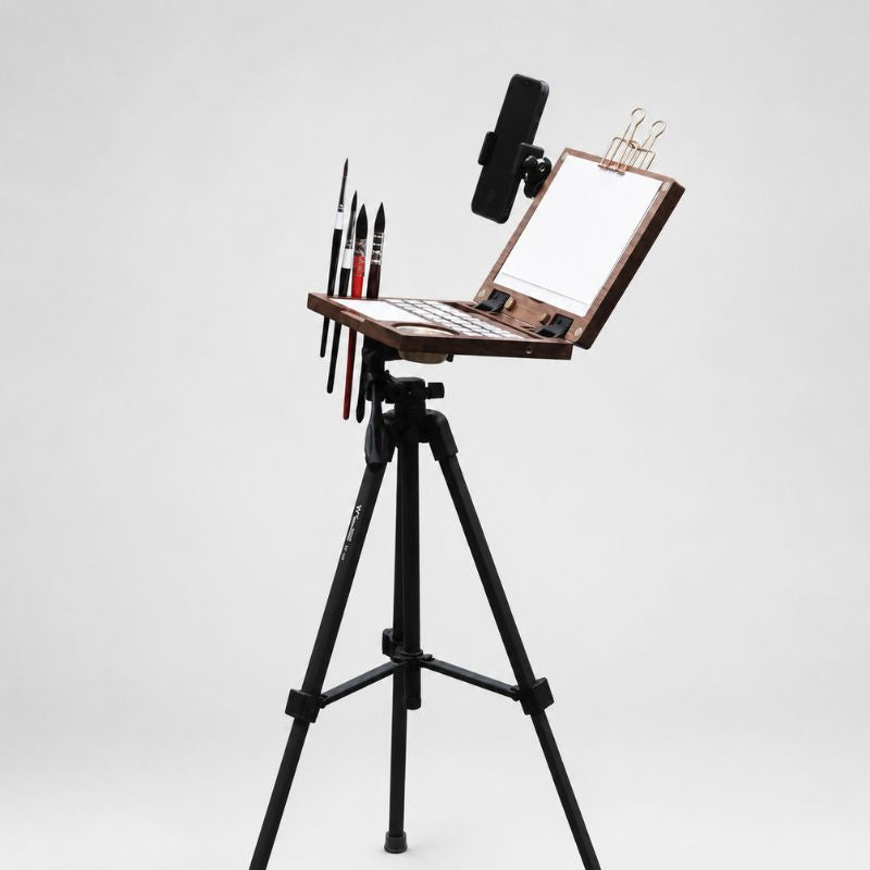 Walnut art kit mounted on a black tripod on with brushes and a phone holder 